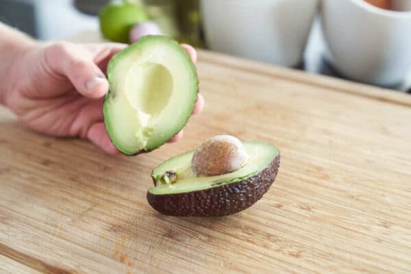 Avocado mit einem Messer bis in den Kern schneiden und öffnen