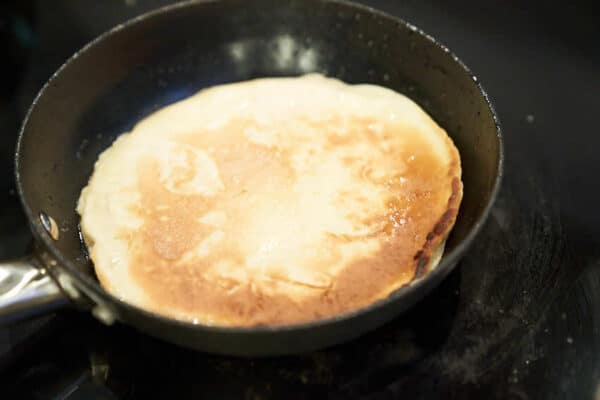 Den Apfelpfannkuchen von beiden Seiten goldbraun braten und servieren.