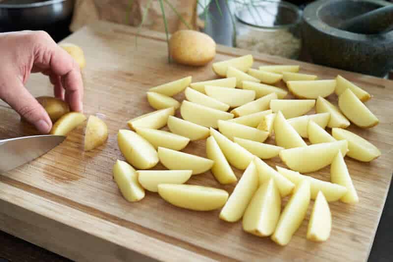 Halbierte Kartoffelspalten auf Backblech